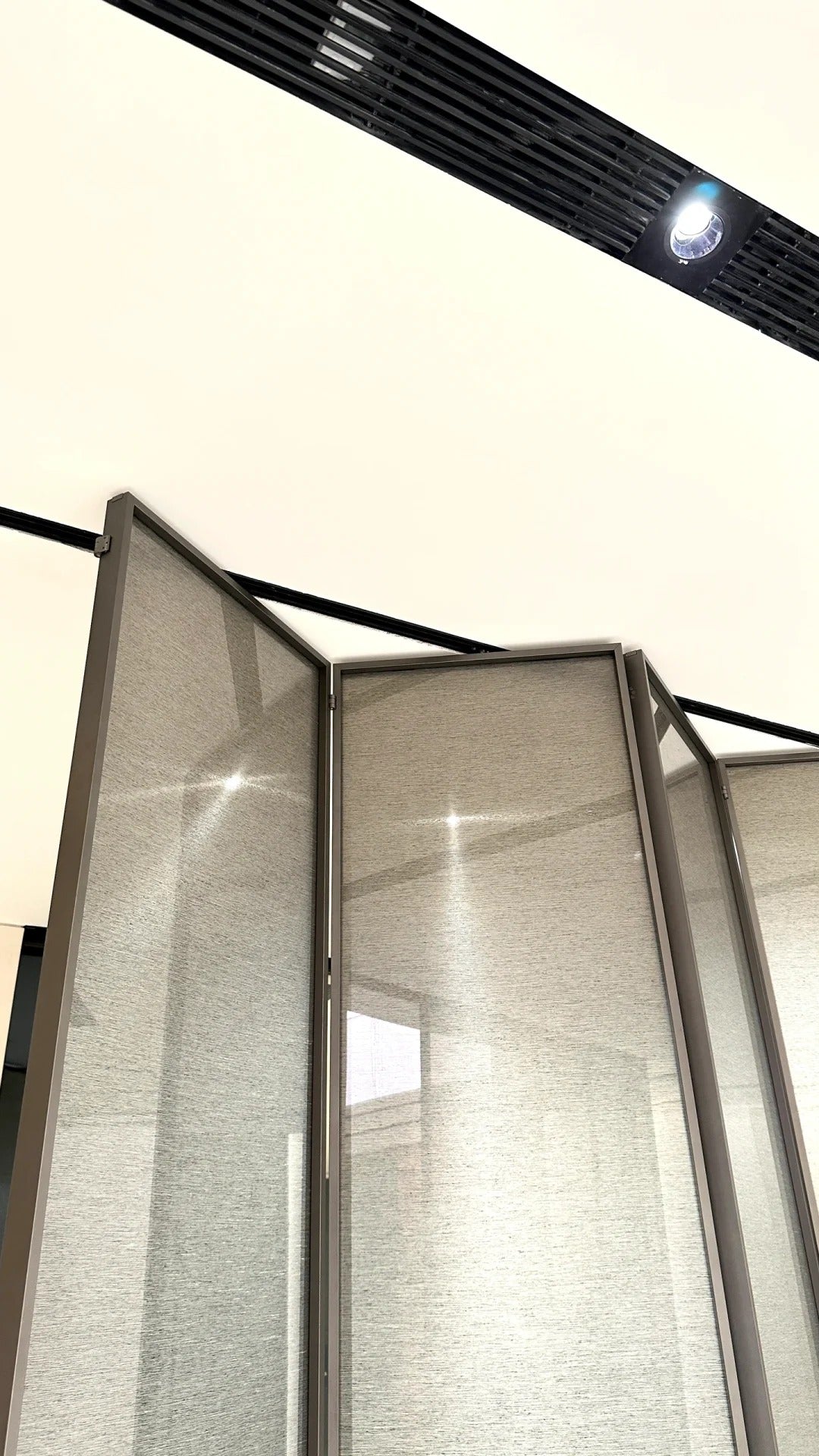 Rothnow aluminum 16x45 Series slim frame bi-fold folding door with clear glass and white finish, installed in modern interior.