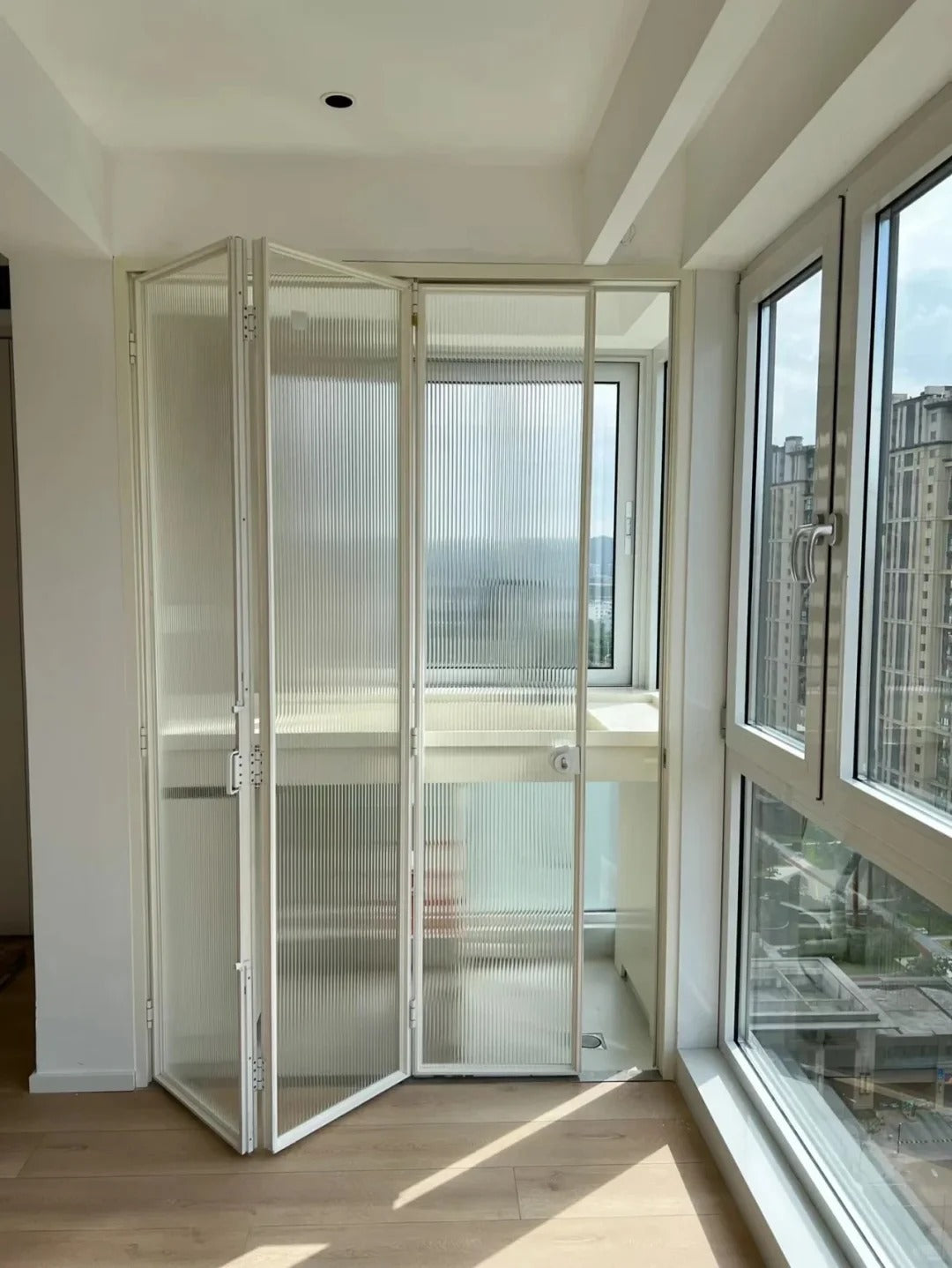 Rothnow aluminum 16x45 series slim frame bi-fold door with waved glass, white finish, large glass panels, and folding design.
