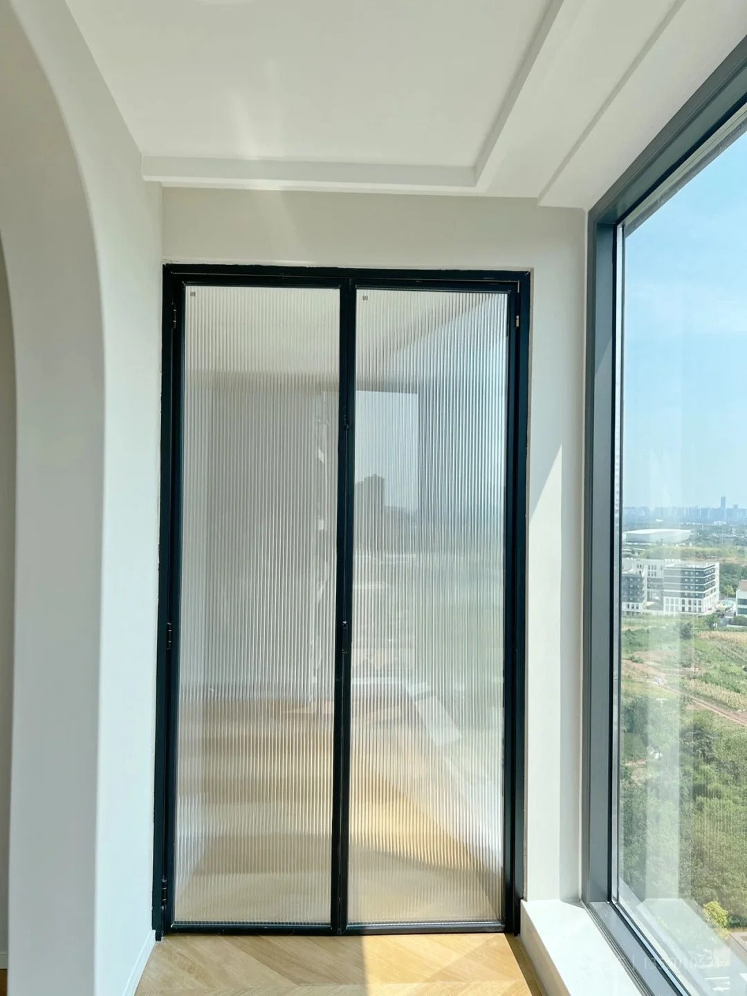 Rothnow aluminum 18x35 series slim frame bi-fold folding door with clear glass and white finish, showcasing modern interior design.