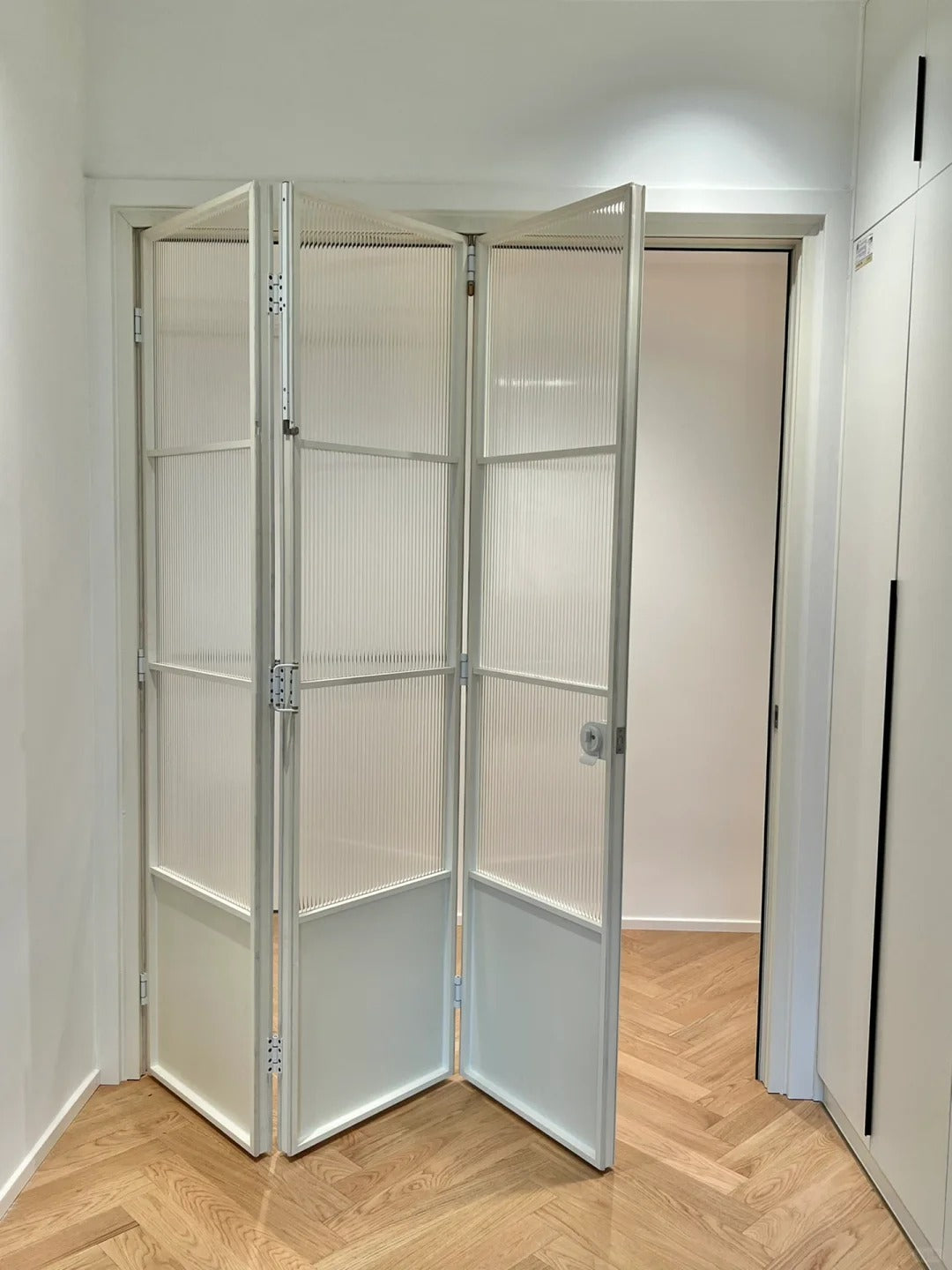 Rothnow French Style Aluminum Bi-fold Door with clear glass, white slim frame, 18x35 series, suitable for living room spaces.
