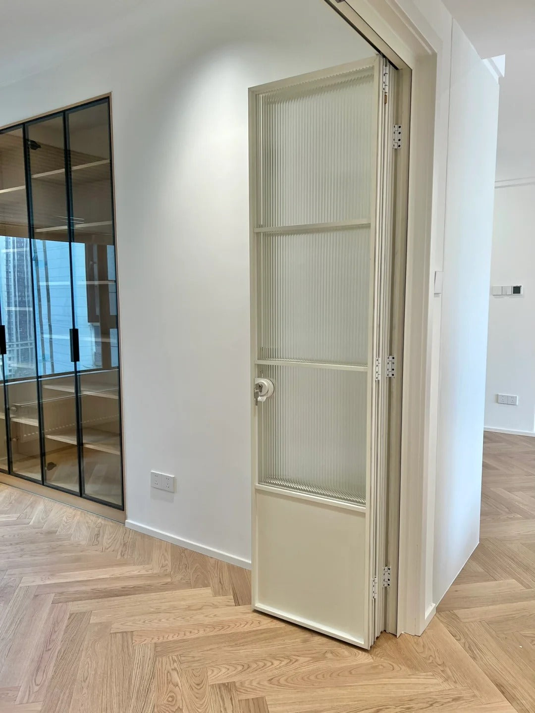 Rothnow French Style Aluminum Bi-fold Door with clear glass, slim white frame, 18x35 series, ideal for living room space.