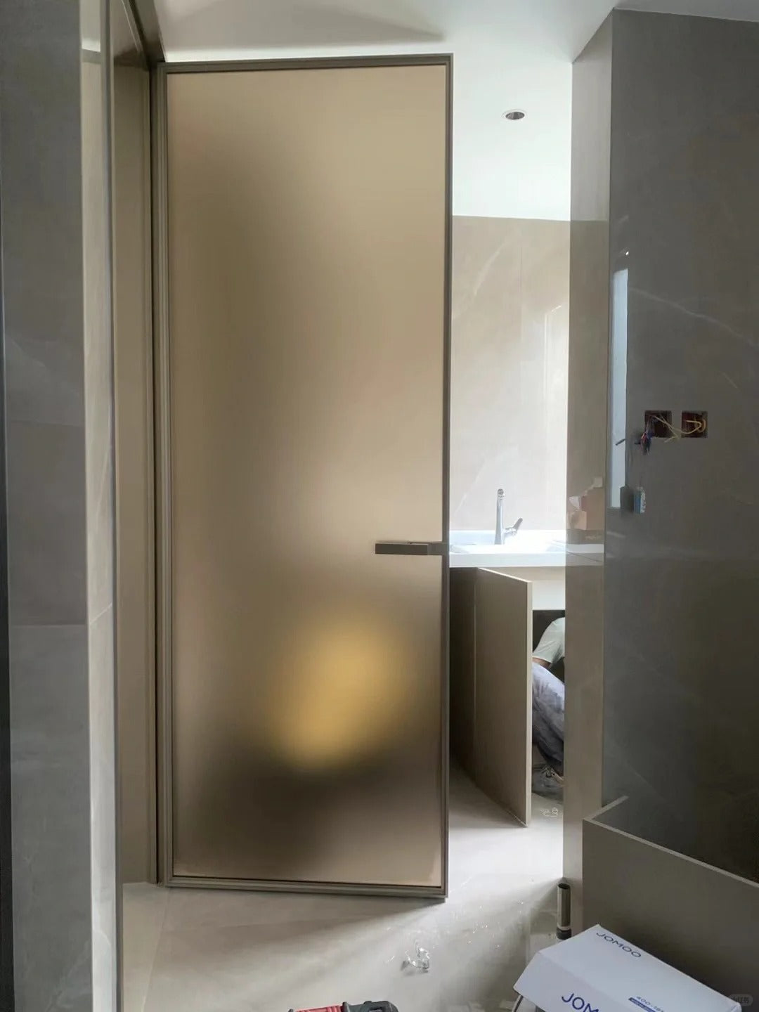 Rothnow aluminum door with 16x45 Series bronze wired glass, white frame, and clear glass panel.