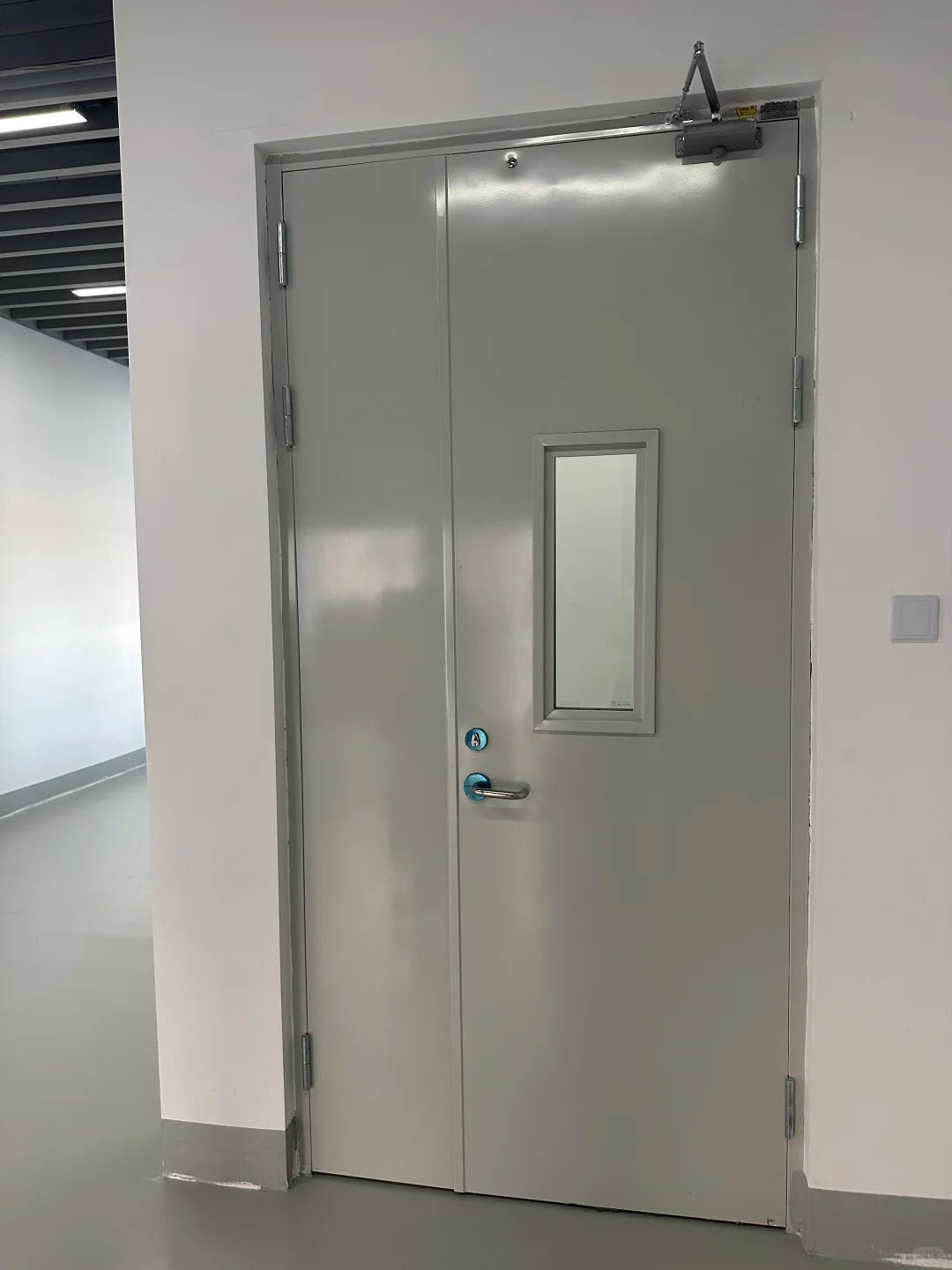 Rothnow steel fire-rated swing door with 990mm width, 2360mm height, and 150mm wall thickness in a building interior.