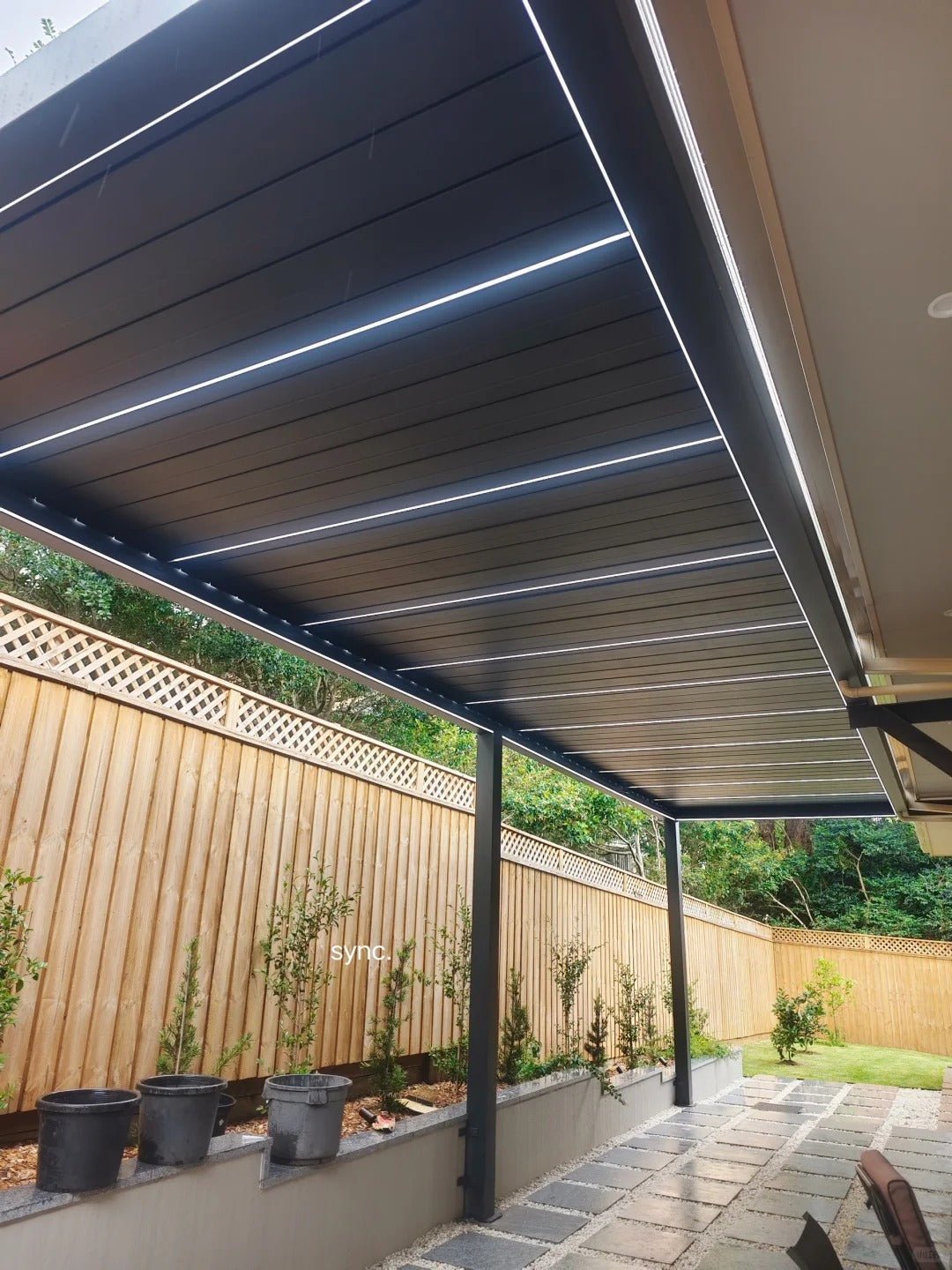 Black Rothnow aluminum climate pergola with sleek ceiling design, custom-sized for outdoor shading and style.