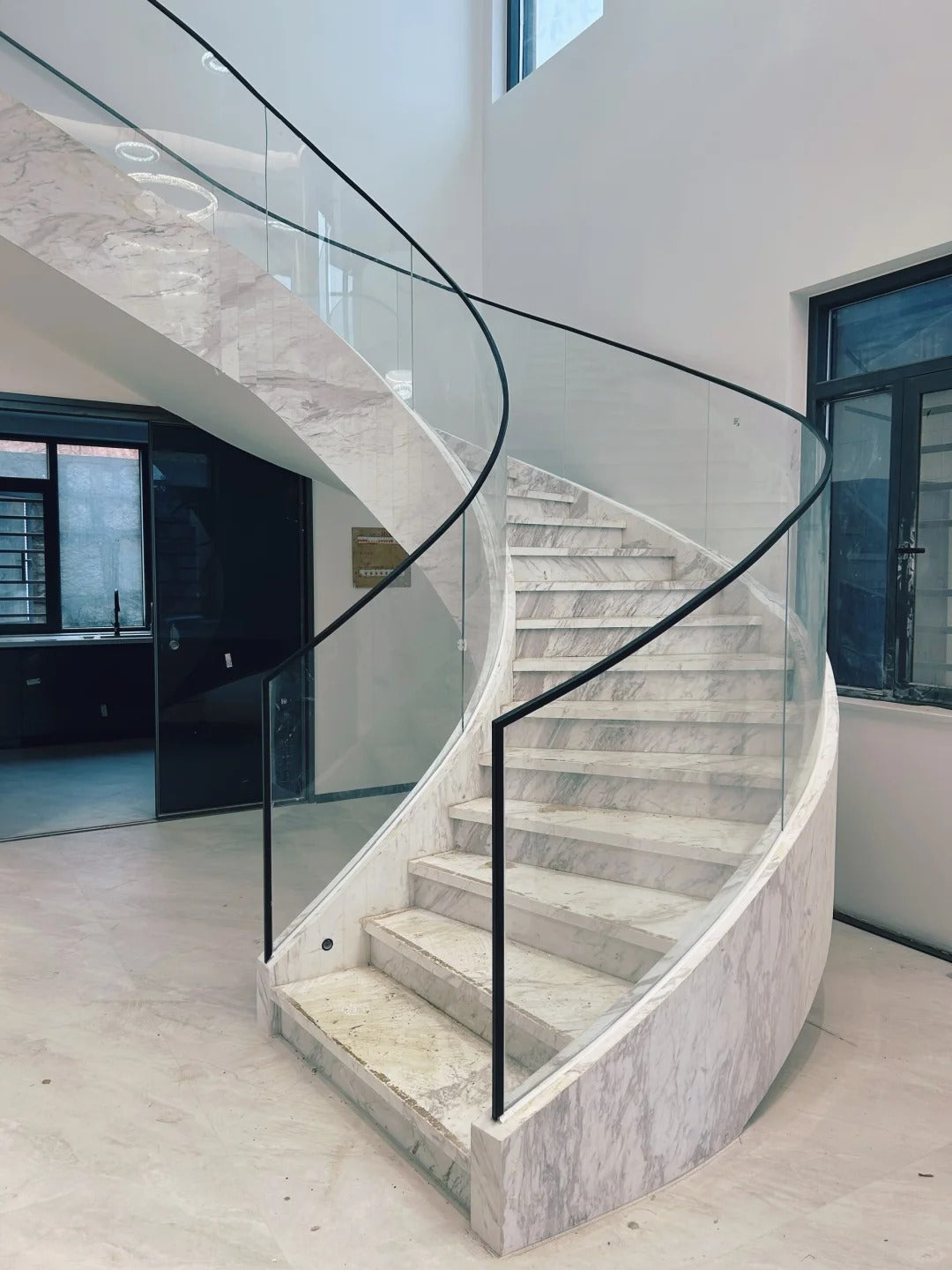 Rothnow® curved staircase in black with stone finish, showcasing a custom-sized elegant staircase design for modern interiors.