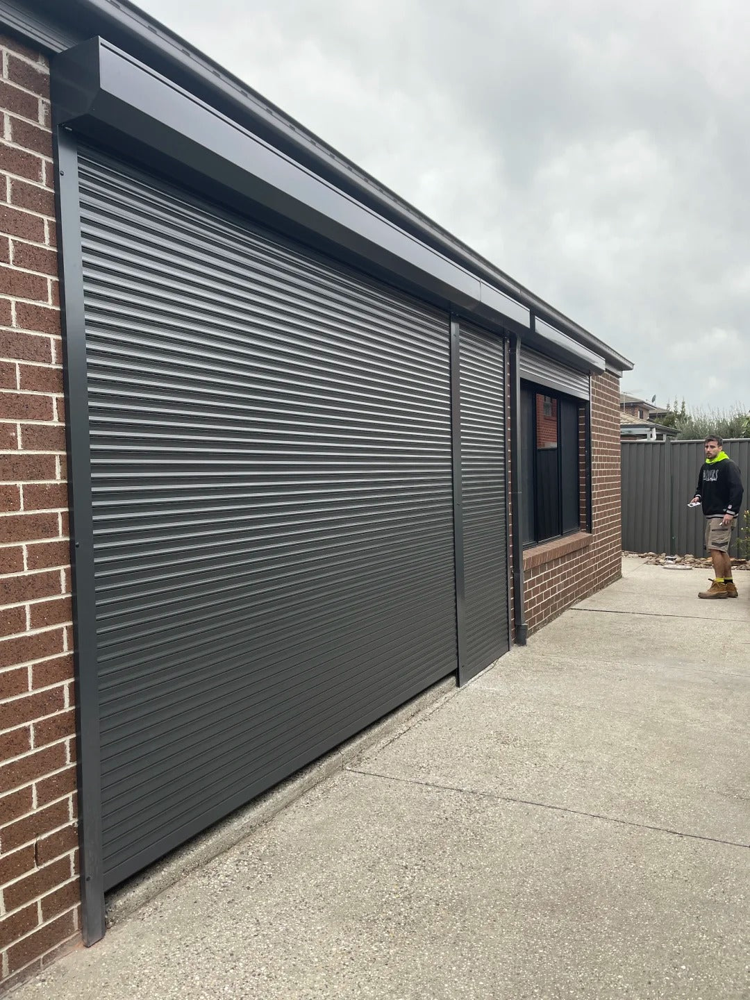 Black Rothnow aluminum roll-up garage door model RNGD08, customized size, featuring sleek aluminum panels for modern garage access.
