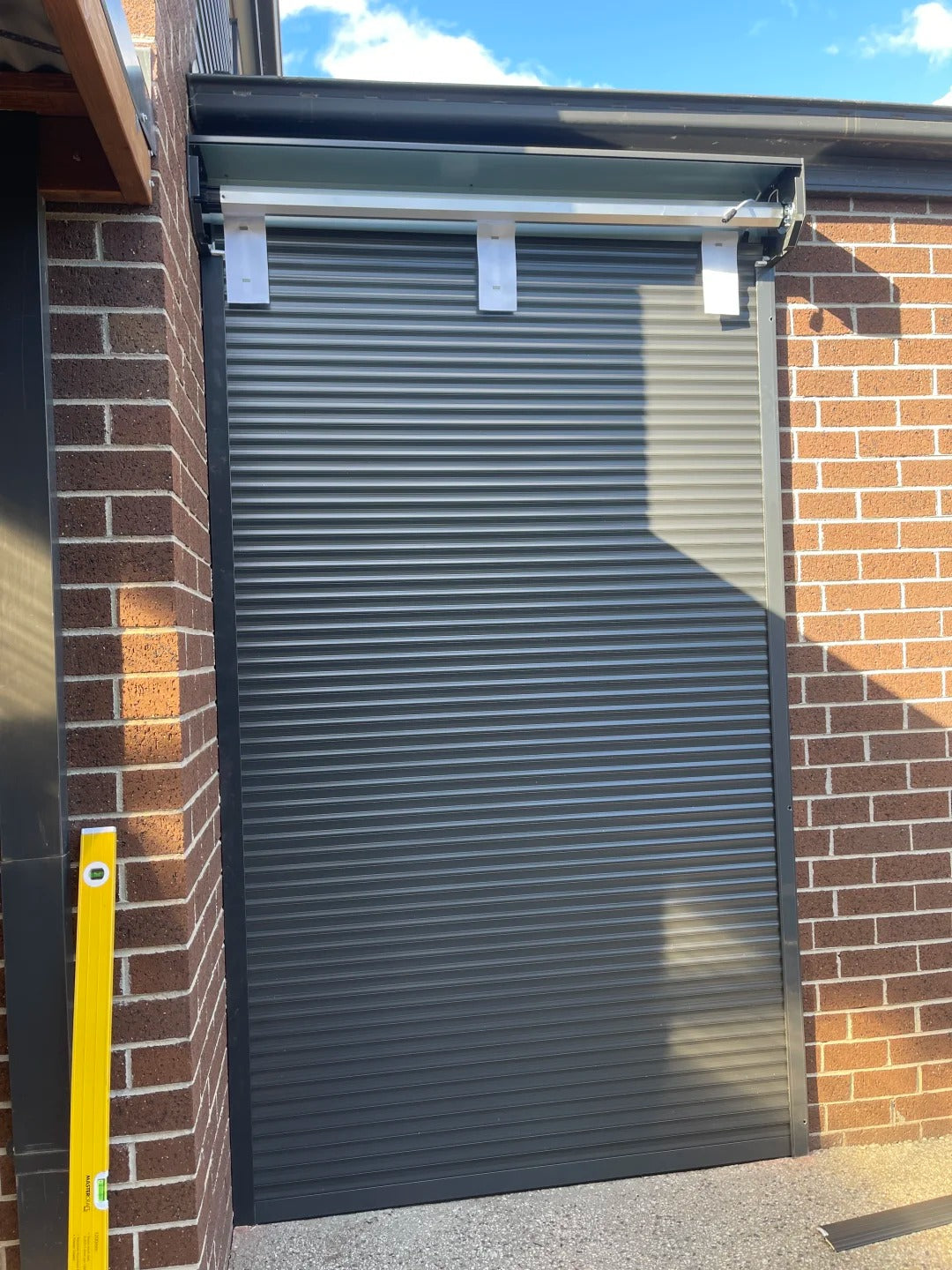 Black Rothnow aluminum roll-up garage door, customized size, with sleek, modern design for residential or commercial use.