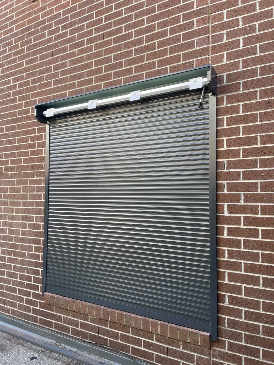 Black Rothnow aluminum roll-up garage door, custom-sized for secure and stylish garage entry.