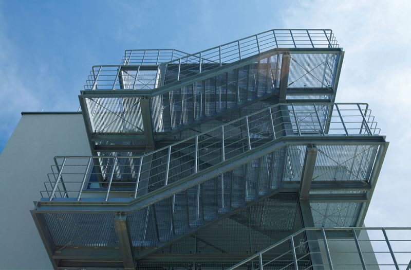 Black Rothnow outdoor staircase with sturdy metal steps and handrails, designed as a fire escape ladder for building safety.