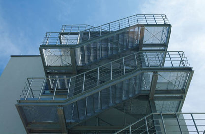 Black Rothnow outdoor staircase with sturdy metal steps and handrails, designed as a fire escape ladder for building safety.
