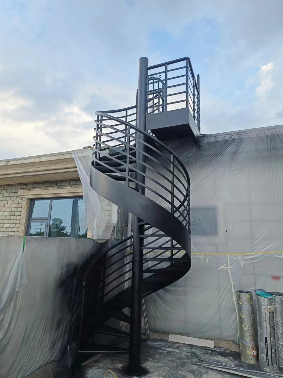 Rothnow® outdoor black spiral staircase made of carbon steel, featuring a custom size design with curved steps and safety handrails.