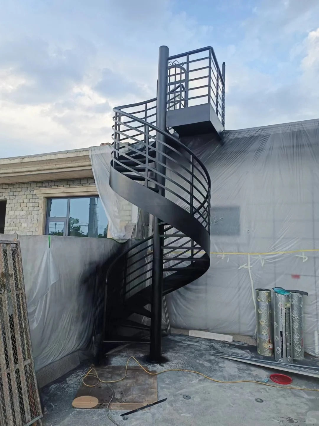 Rothnow outdoor carbon steel spiral staircase with black finish, custom-sized, featuring curved steps and railing for exterior use.
